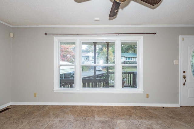 unfurnished room with ornamental molding, visible vents, ceiling fan, and baseboards