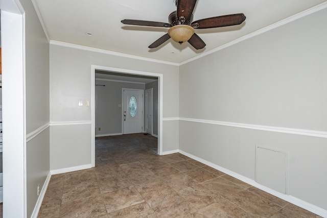 spare room featuring ornamental molding, baseboards, and a ceiling fan