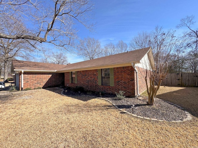 view of home's exterior with fence and brick siding