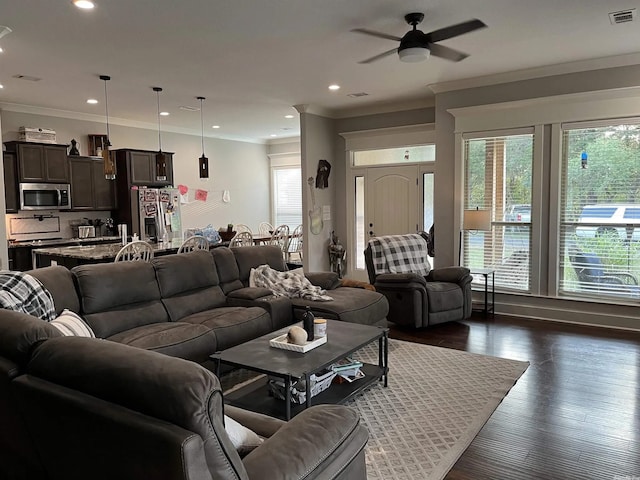 living room featuring ornamental molding, dark wood-style flooring, plenty of natural light, and visible vents