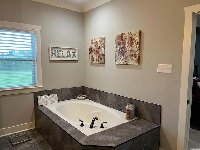 bathroom with a garden tub and baseboards