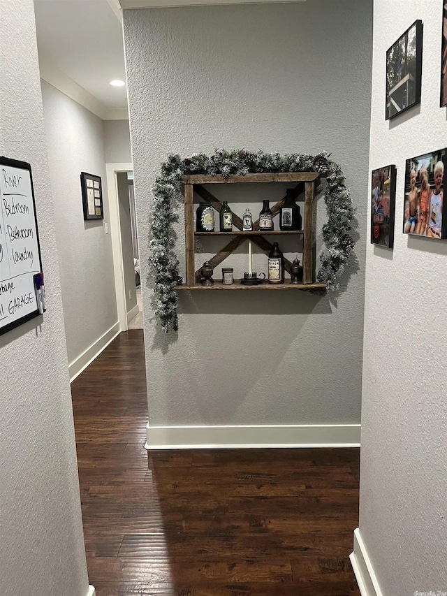 hall with baseboards, dark wood finished floors, and a textured wall