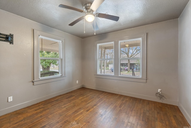 spare room with ceiling fan, baseboards, dark wood finished floors, and a textured ceiling