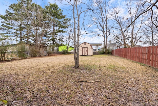 view of yard with a shed, a fenced backyard, and an outdoor structure