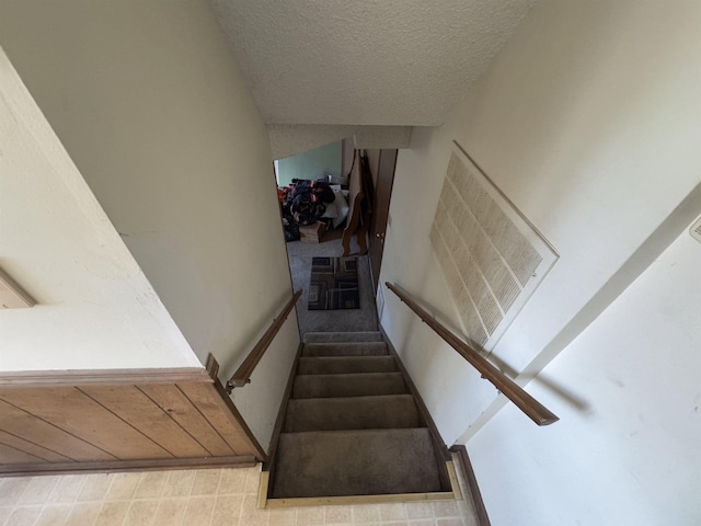 stairs featuring visible vents and a textured ceiling