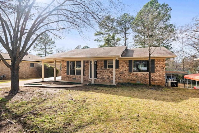 rear view of house featuring crawl space, a patio area, a lawn, and brick siding