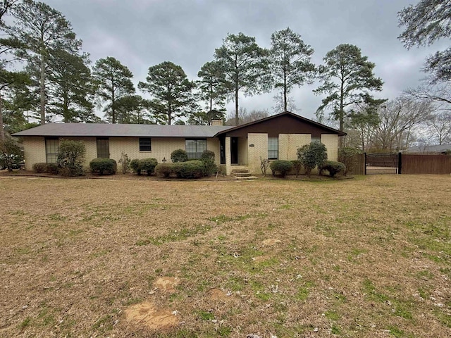 159 Ables Dr, El Dorado, AR 71730 - view of front facade with a front yard, brick siding, fence, and a chimney