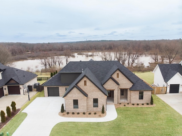 french country style house featuring a water view, fence, and a front yard