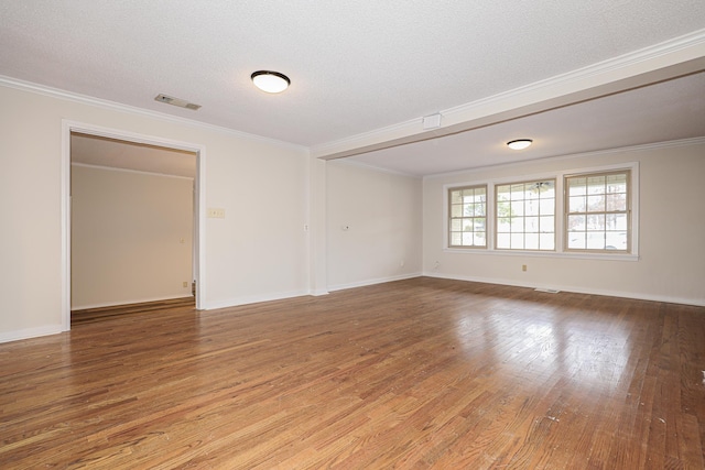 spare room with crown molding, a textured ceiling, visible vents, and wood finished floors