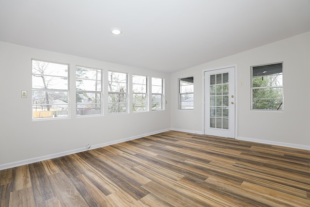 empty room with vaulted ceiling, dark wood-type flooring, recessed lighting, and baseboards