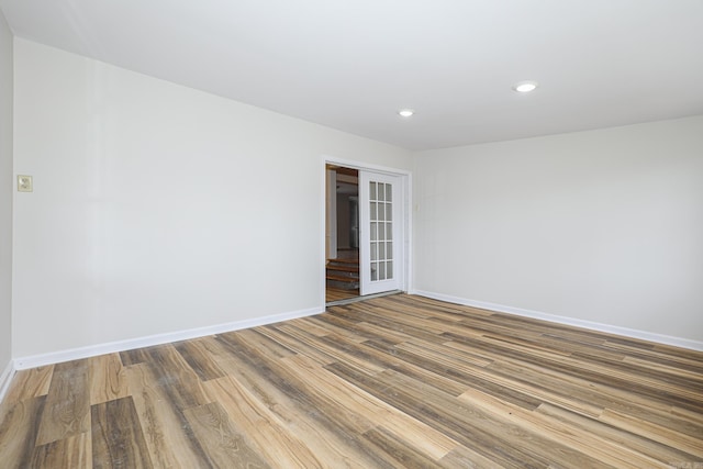 unfurnished room with recessed lighting, french doors, baseboards, and wood finished floors