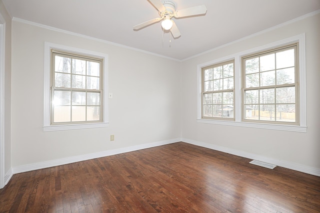 empty room with baseboards, visible vents, dark wood finished floors, and ornamental molding