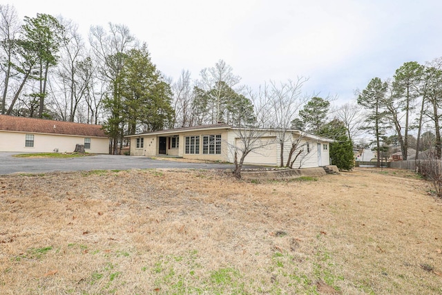 ranch-style house featuring a garage and aphalt driveway