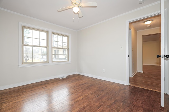 spare room featuring visible vents, dark wood-type flooring, and ornamental molding