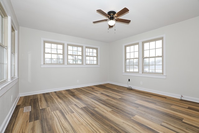 empty room featuring visible vents, baseboards, ceiling fan, and wood finished floors