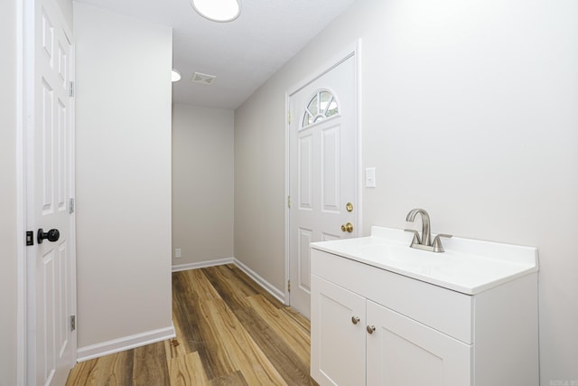 interior space featuring vanity, wood finished floors, visible vents, and baseboards