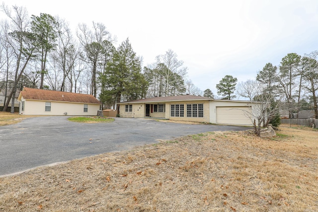 ranch-style house featuring a garage and driveway