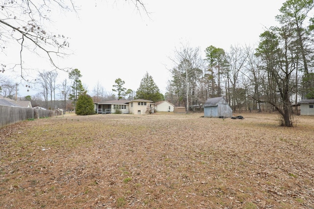 view of yard with a shed, fence, and an outdoor structure