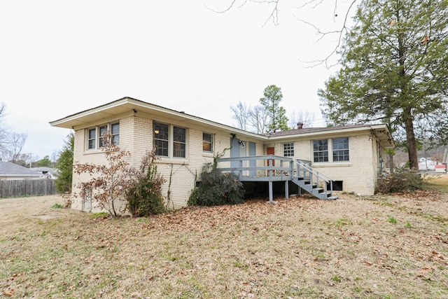 rear view of house featuring a lawn, stairway, fence, a wooden deck, and brick siding