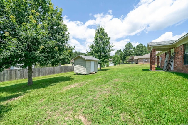 view of yard with an outbuilding, fence, and a shed