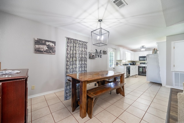 dining area featuring light tile patterned floors, an inviting chandelier, visible vents, and baseboards