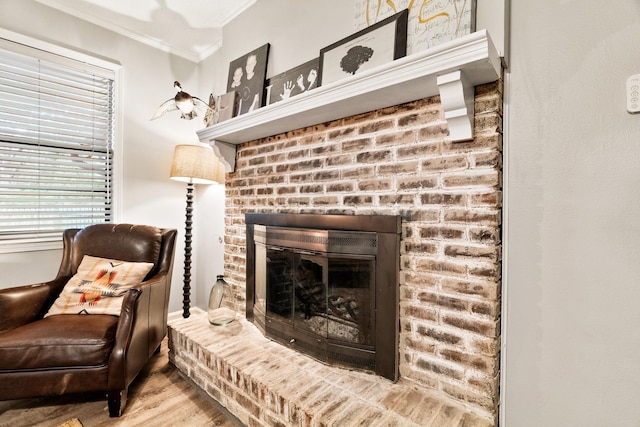 sitting room with a fireplace, crown molding, and wood finished floors