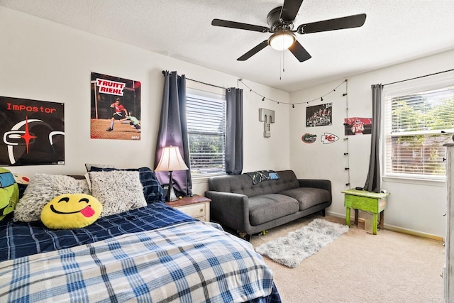 bedroom with a textured ceiling, multiple windows, and carpet