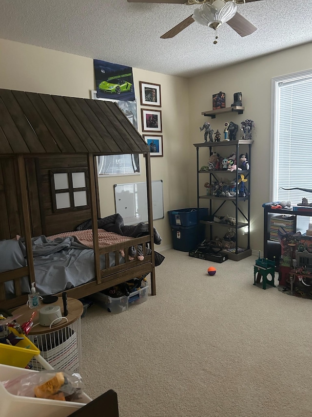 carpeted bedroom with ceiling fan and a textured ceiling