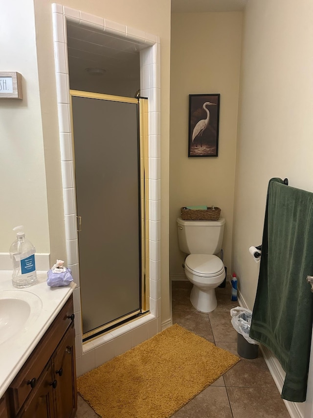full bathroom featuring tile patterned flooring, baseboards, toilet, a stall shower, and vanity