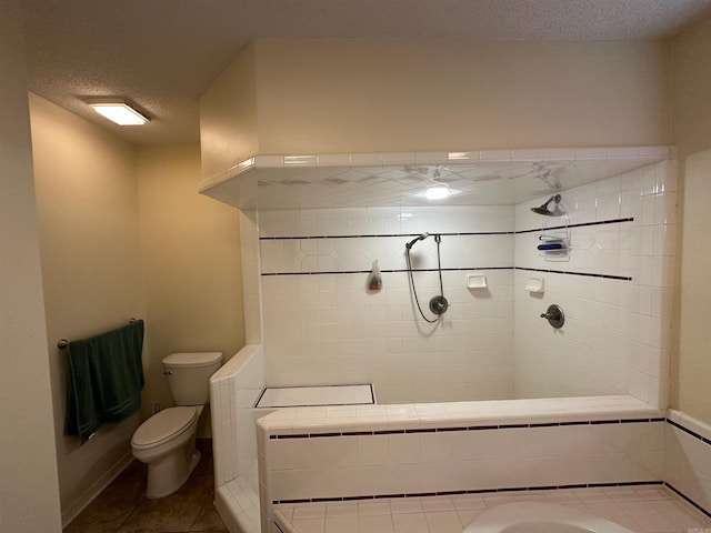 full bathroom with tile patterned floors, toilet, washer / clothes dryer, a textured ceiling, and a tile shower