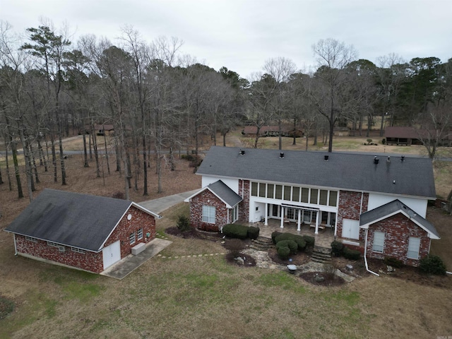 back of house featuring a yard, a patio, and brick siding