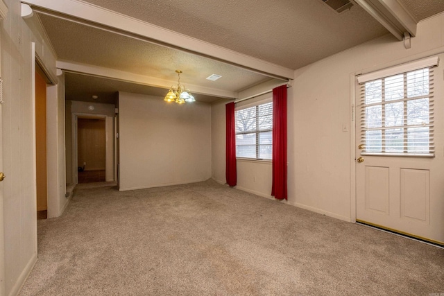 empty room featuring a textured ceiling, a notable chandelier, light carpet, visible vents, and beam ceiling