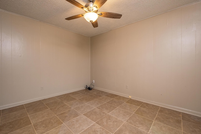 empty room with ceiling fan, a textured ceiling, and tile patterned floors