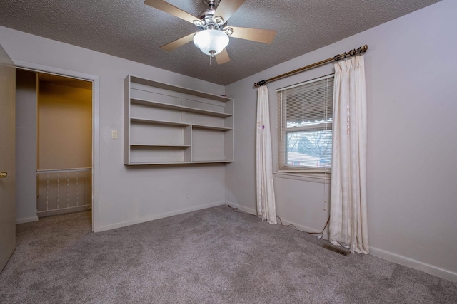 unfurnished bedroom featuring a ceiling fan, baseboards, a textured ceiling, and light colored carpet