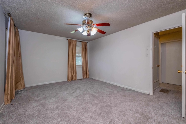 empty room featuring baseboards, a textured ceiling, a ceiling fan, and light colored carpet