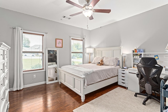 bedroom with ceiling fan, visible vents, baseboards, and dark wood-type flooring