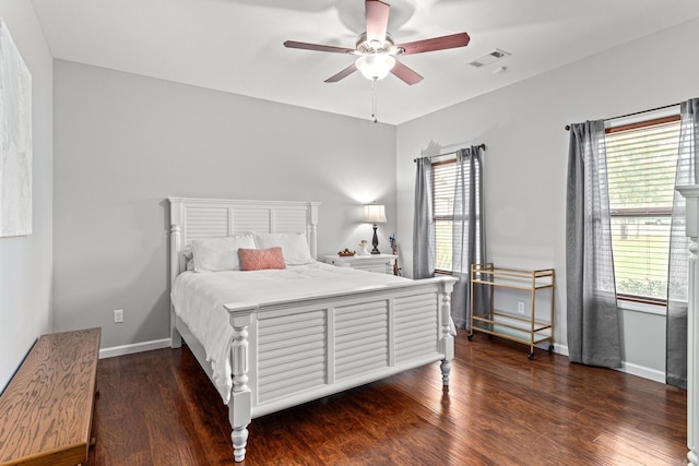 bedroom with dark wood-style floors, multiple windows, visible vents, and baseboards