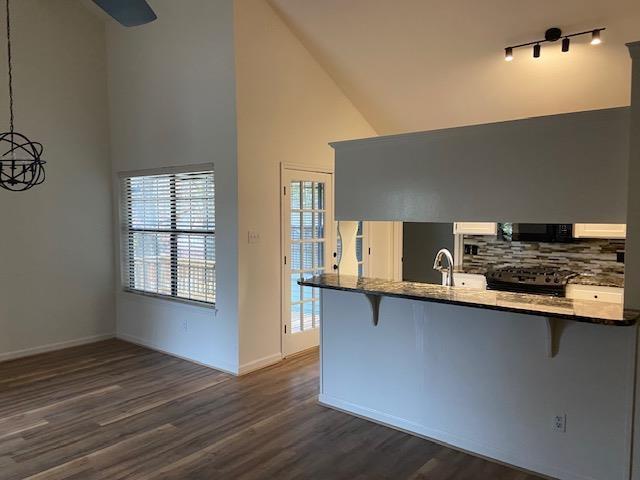 kitchen featuring dark countertops, pendant lighting, a peninsula, and a breakfast bar area