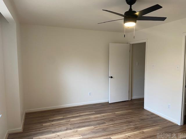 spare room with ceiling fan, baseboards, and wood finished floors