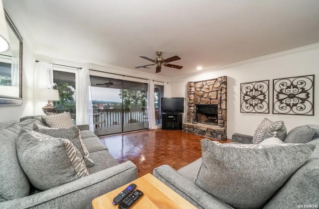 living area with a fireplace, ornamental molding, and a ceiling fan