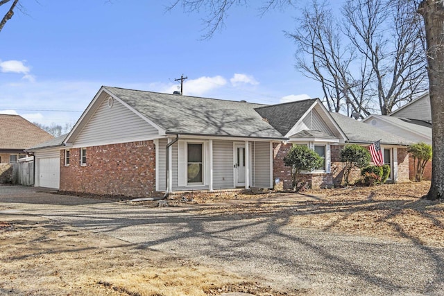 single story home featuring brick siding, driveway, and an attached garage