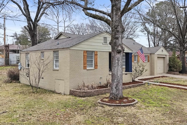 view of side of home featuring brick siding, a yard, a shingled roof, an attached garage, and crawl space