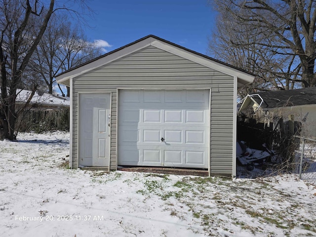 snow covered garage featuring a detached garage