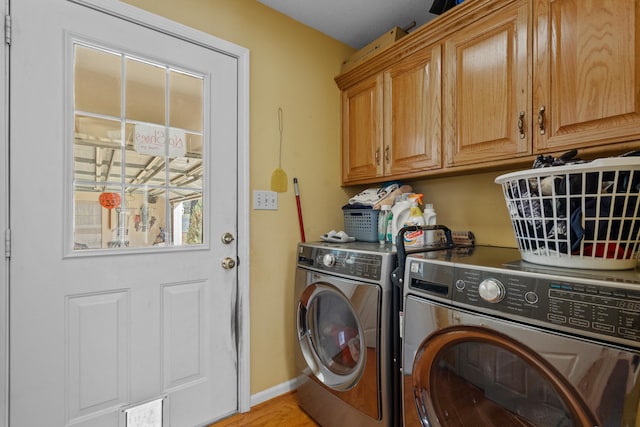 laundry area featuring cabinet space, baseboards, and separate washer and dryer