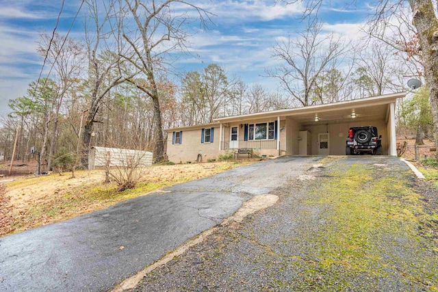 view of front of house with driveway, a porch, and an attached carport