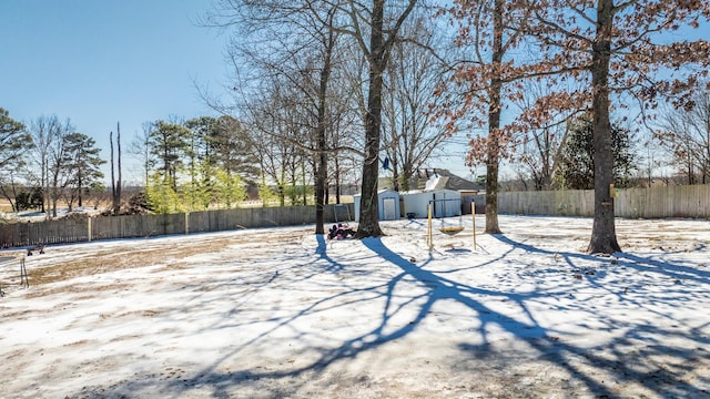 snowy yard with an outbuilding, fence, and a shed