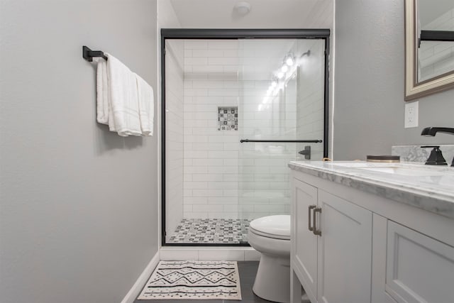 bathroom featuring toilet, a stall shower, and vanity