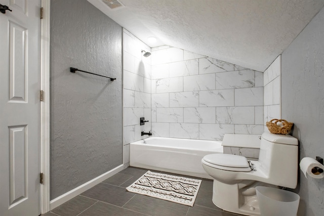 full bath featuring vaulted ceiling, shower / bath combination, a textured wall, and a textured ceiling