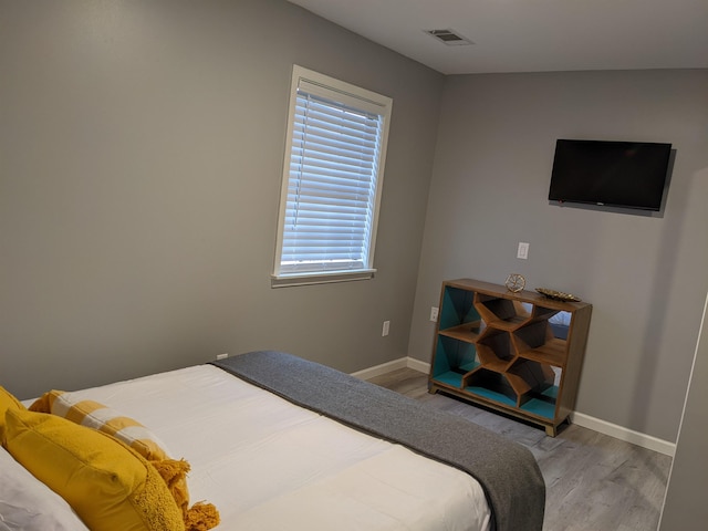 bedroom with light wood-type flooring, baseboards, and visible vents