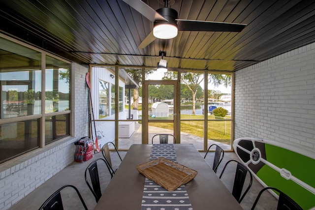 sunroom featuring ceiling fan, a water view, and plenty of natural light